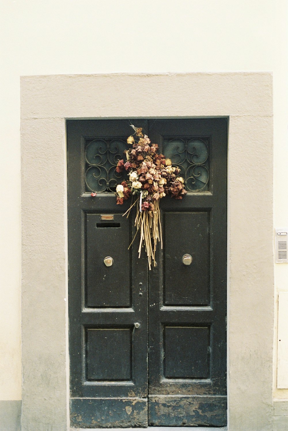 uma porta que tem um ramo de flores sobre ela