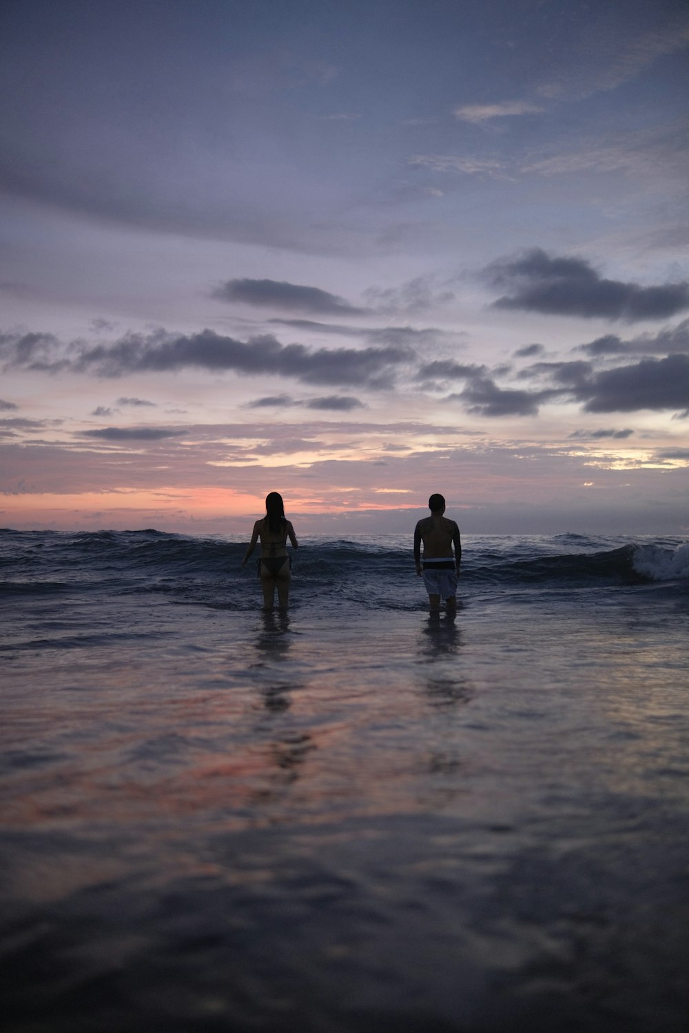 a couple of people that are standing in the water