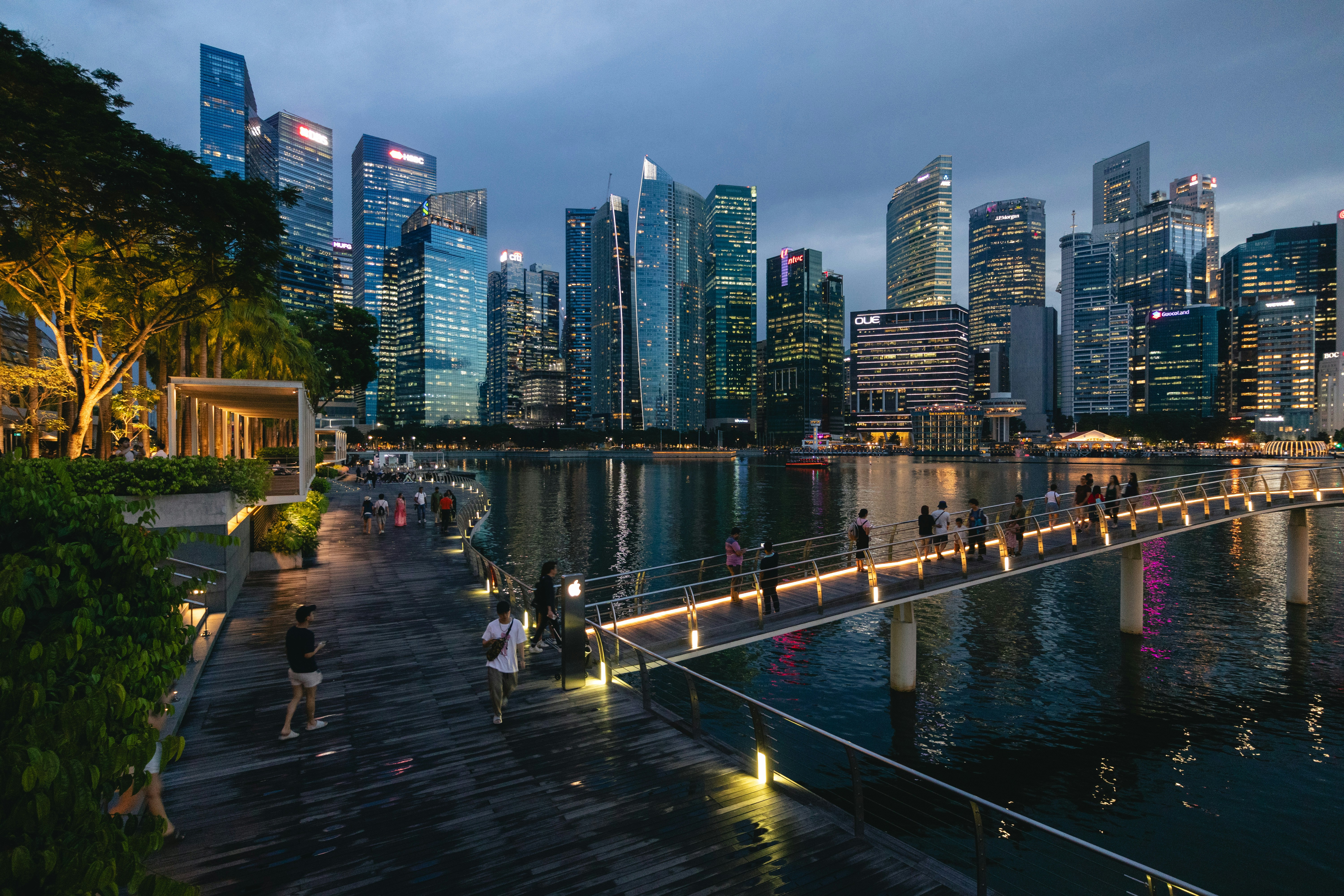 people walking on a bridge over a body of water