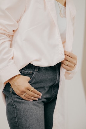 A casual yet trendy outfit featuring a chic top and jeans, accessorized with delicate jewelry.