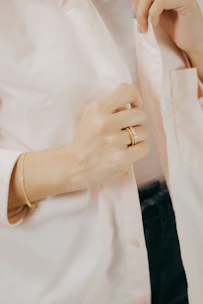 Close-up of hands delicately arranging gold accents on a textured charcoal background.