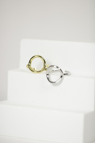 Set of stainless steel rings with sleek designs displayed on a minimalistic white surface