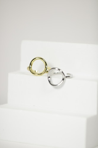 Set of stainless steel rings with sleek designs displayed on a minimalistic white surface