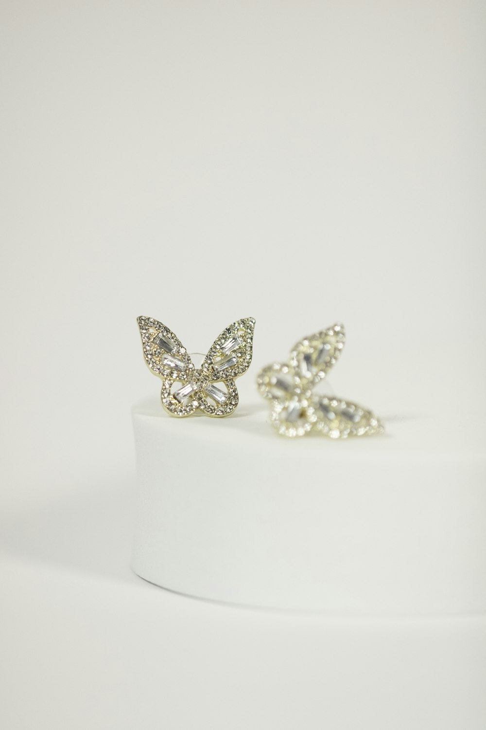 a pair of diamond earrings on a white surface