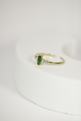 Close-up of a handcrafted emerald ring sparkling under soft light, showcasing the rich green hues from Panjshir Valley.