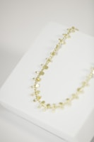 Delicate necklaces and earrings displayed on a rustic jewelry stand.