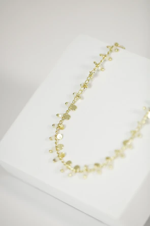 Delicate gold Korean necklace layered over a simple white blouse.