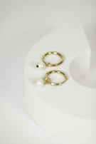Minimalist silver hoops displayed on a rustic wooden surface.