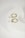 Two gold hoop earrings with white pearl pendants are placed on a white, curved, hollow object. The setup has a minimalist and elegant aesthetic.