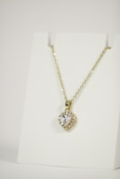 Modern gold and diamond pendant necklace displayed on a clean white background.