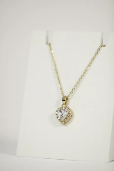 Personalised gold necklace with a heart-shaped pendant engraved with initials.