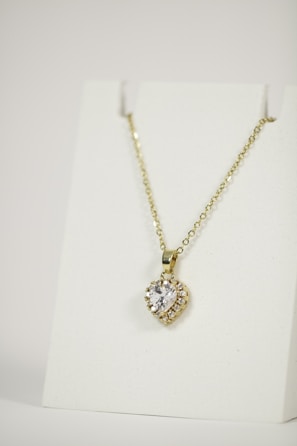 Modern gold and diamond pendant necklace displayed on a clean white background.