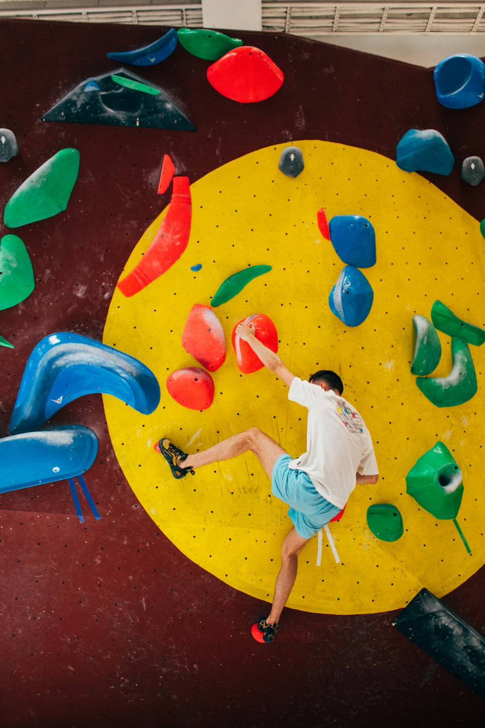 a man climbing on a climbing wall in a gym