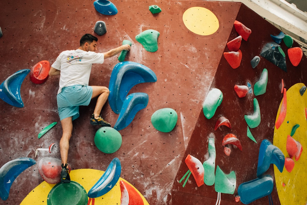 a man climbing up the side of a climbing wall