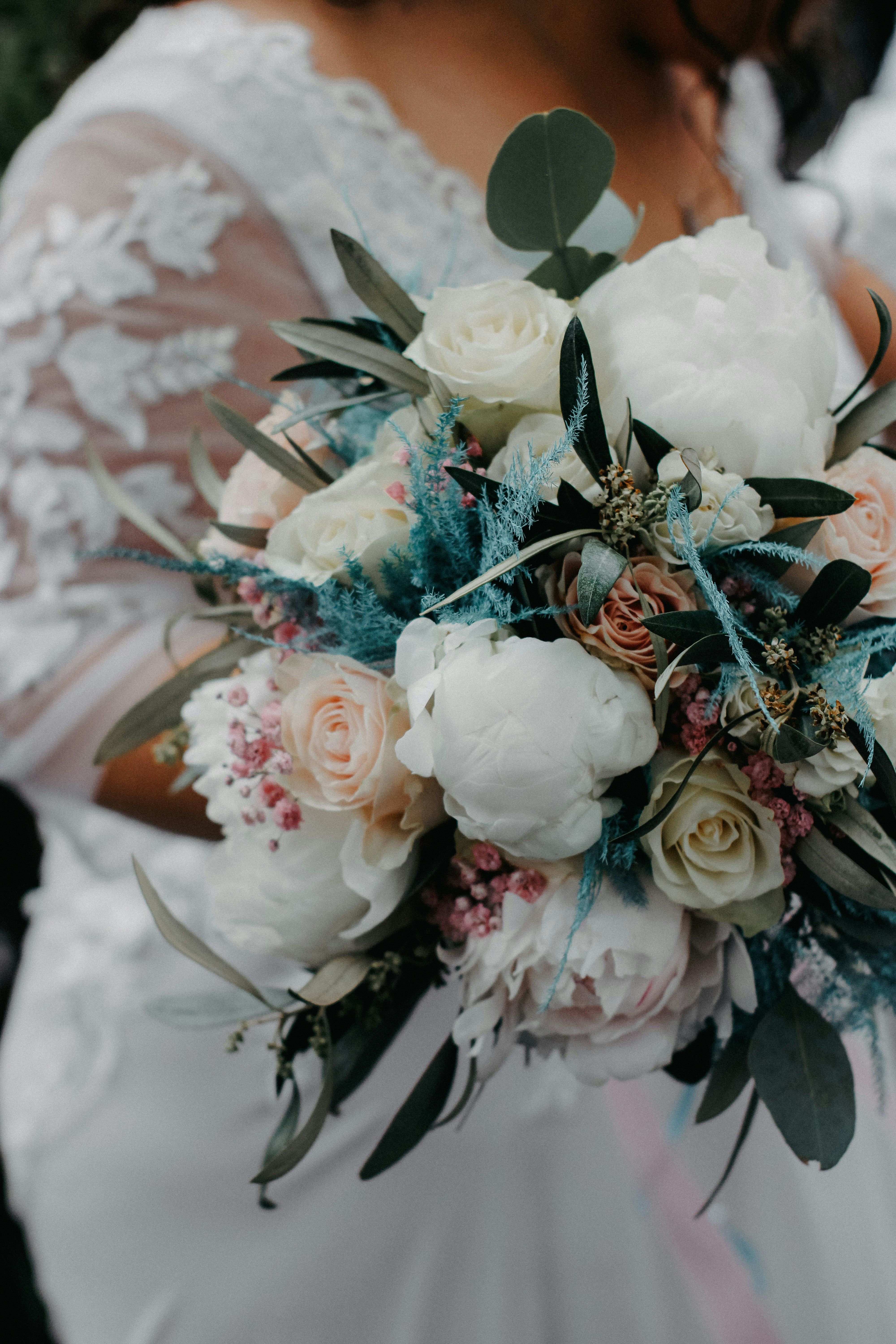 a bride holding a bouquet of white and pink flowers