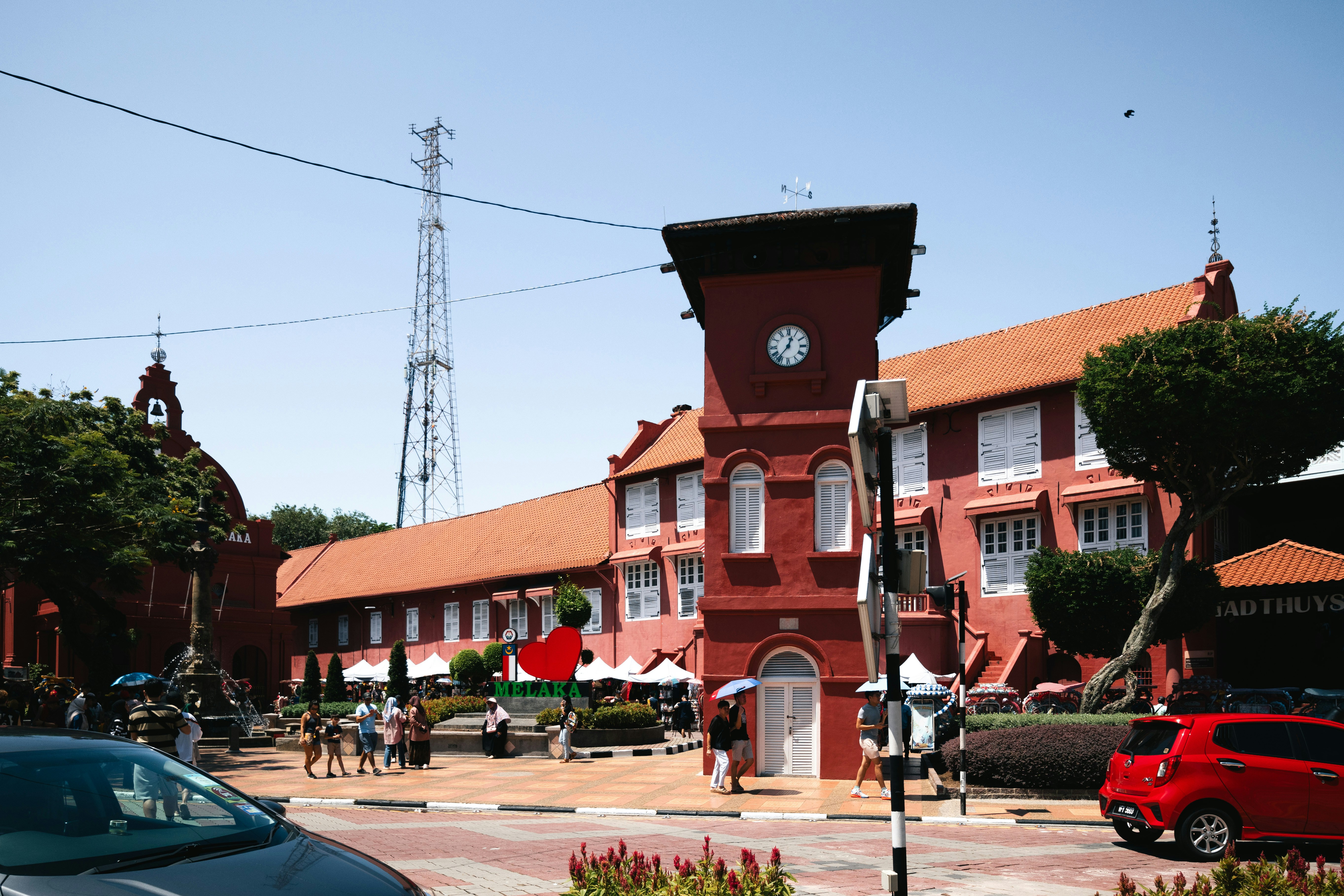 Un edificio rojo con un reloj en el costado