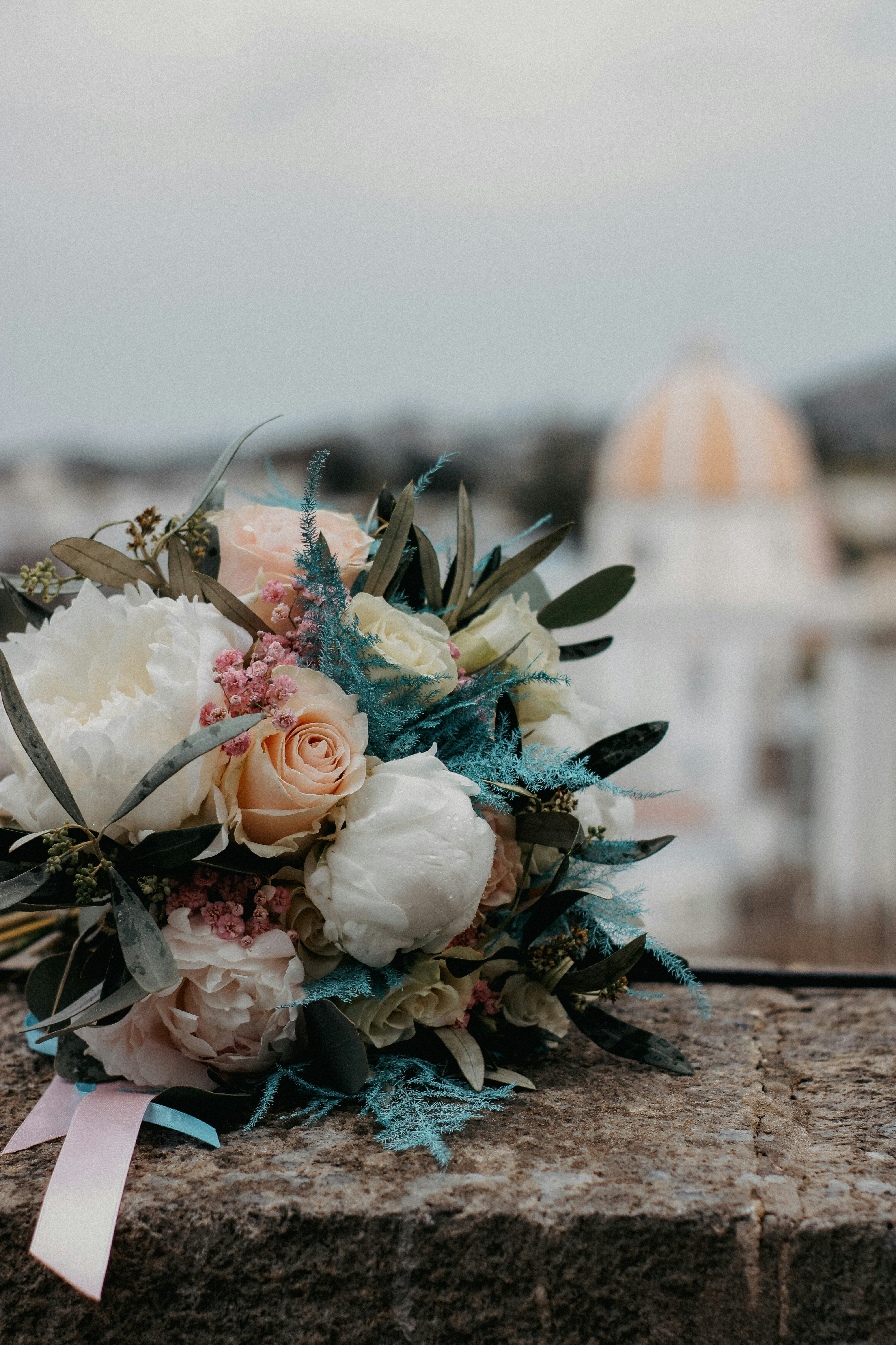 a bouquet of flowers sitting on top of a stone wall