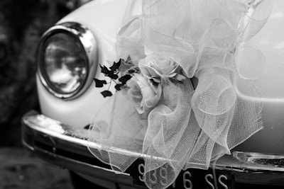 Close-up of a beautifully decorated vintage wedding car with ornate floral arrangements.