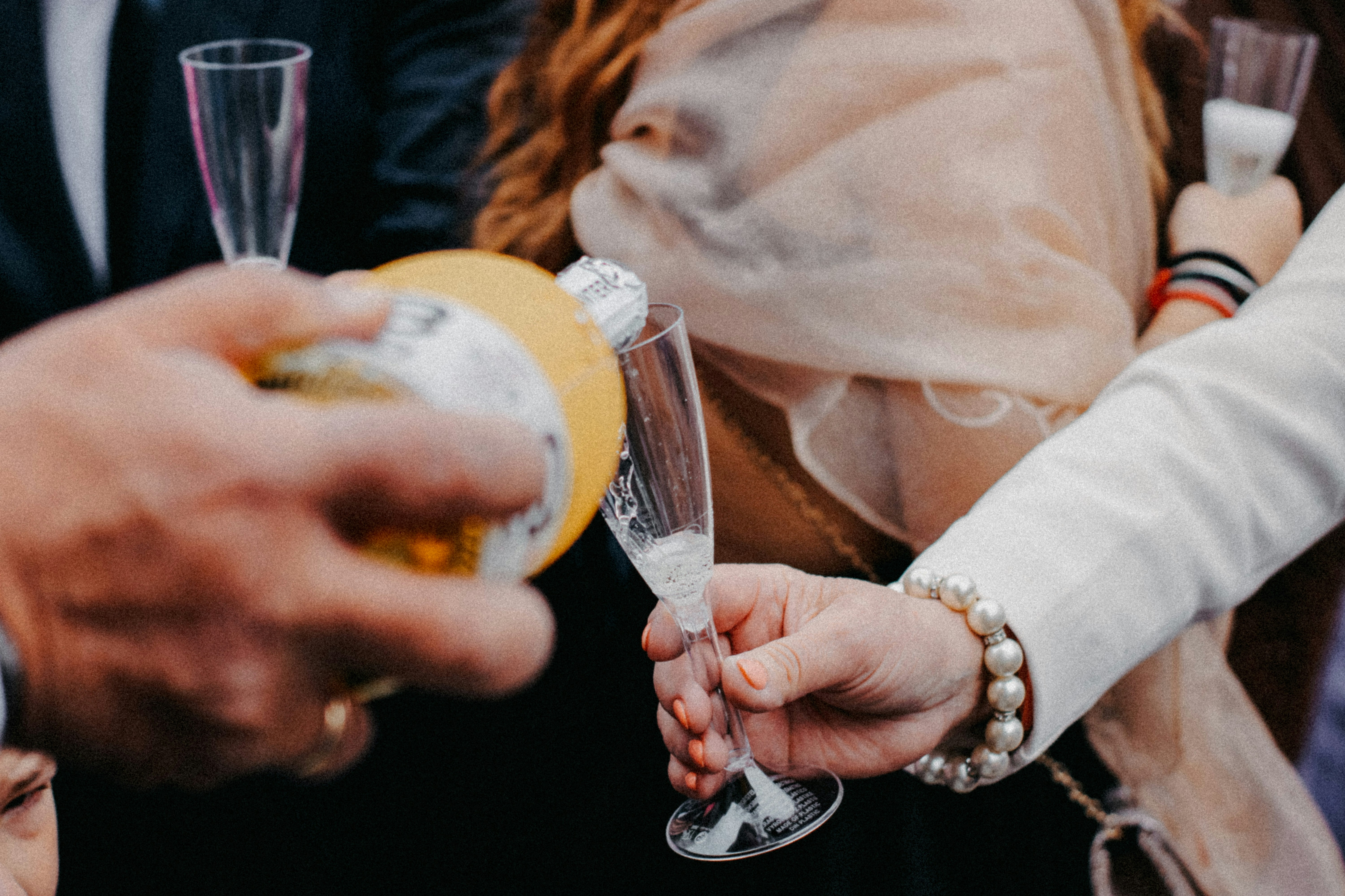 a group of people standing around each other holding wine glasses