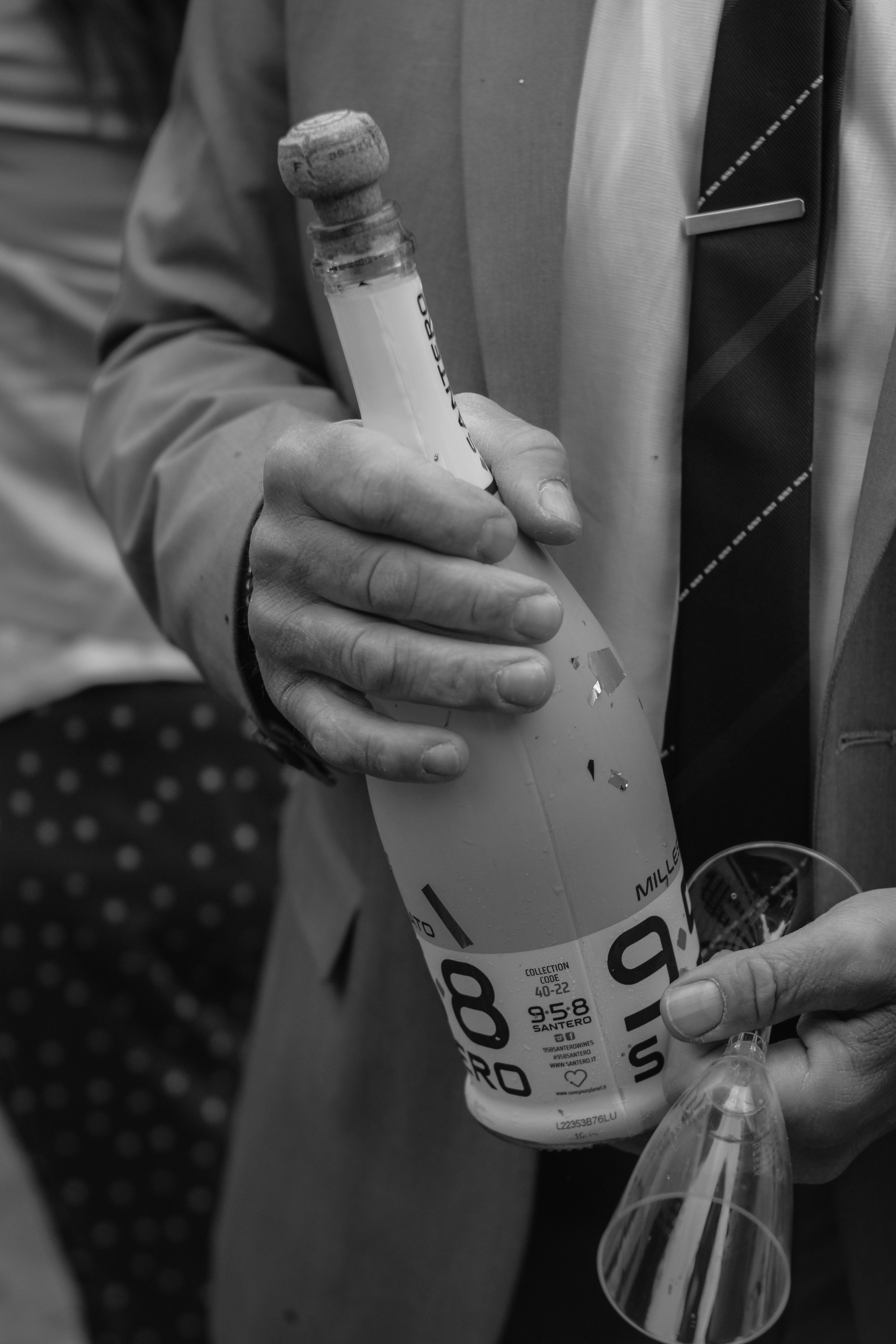 a man in a suit holding a bottle of alcohol