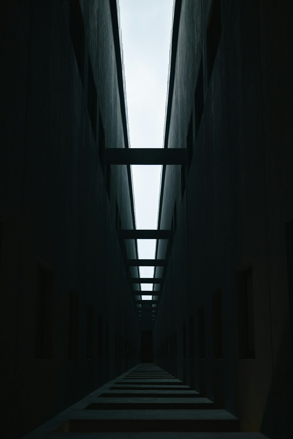 a dark hallway with stairs leading up to the sky