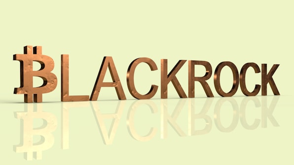 The word 'BLACKROCK' is displayed in bold, metallic 3D letters with a reflective effect, set against a light green background. The letter 'B' is stylized to resemble the Bitcoin symbol.