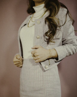 A chic outfit set featuring a matching top and skirt in pastel tones, styled with minimal accessories.