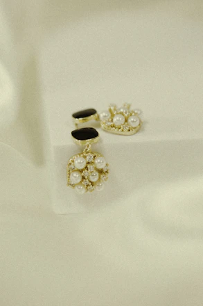 Sophisticated set of women's semi-jewelry including earrings and bracelets in gold and black tones