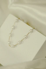 Porcelain necklaces displayed gracefully on a minimalist white marble surface.
