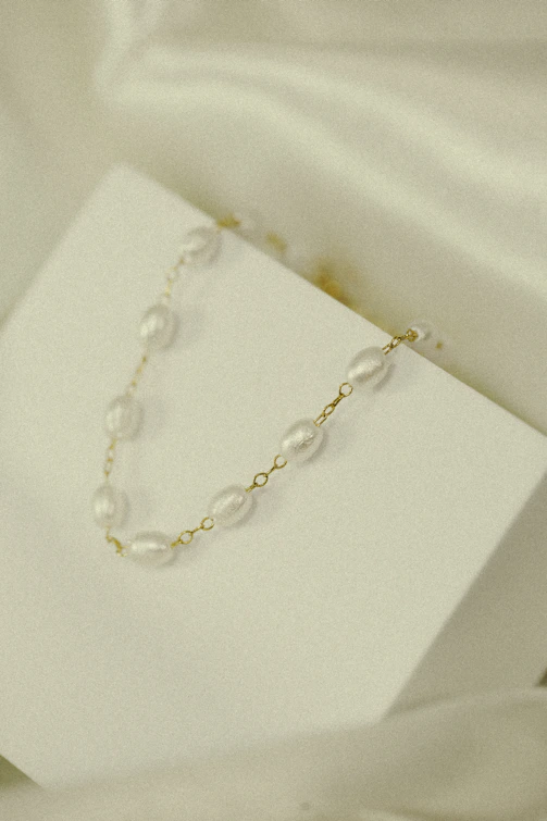 Porcelain necklaces displayed gracefully on a minimalist white marble surface.
