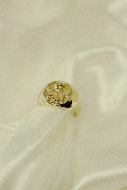 Close-up of a delicate porcelain ring resting on a soft linen fabric.