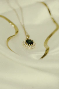 Close-up of a delicate gold necklace with a moonstone pendant resting on soft velvet.