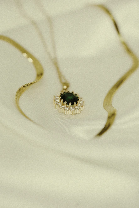 Close-up of a delicate gold necklace with a moonstone pendant resting on soft velvet.