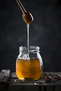 a jar of honey with a wooden spoon