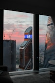 A modern office window view overlooking a city skyline at dusk with financial graphs overlaid.