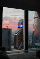 Wide shot of a city skyline at dusk seen through a high-rise office window, representing growth and aspiration.