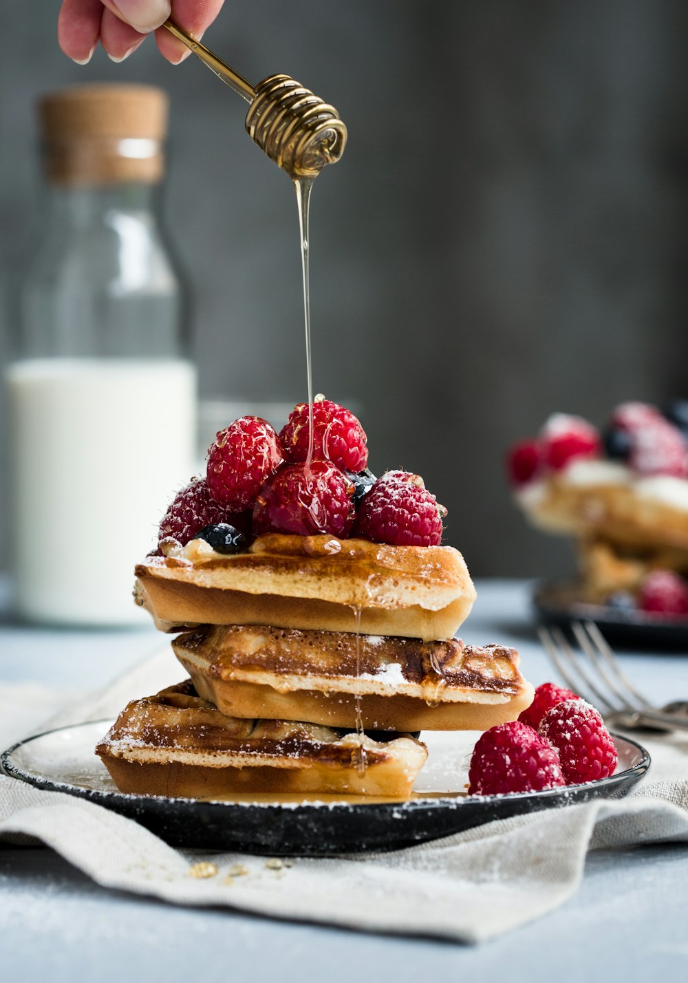 a stack of pancakes topped with berries and syrup