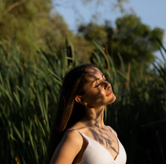 a woman standing in front of tall grass