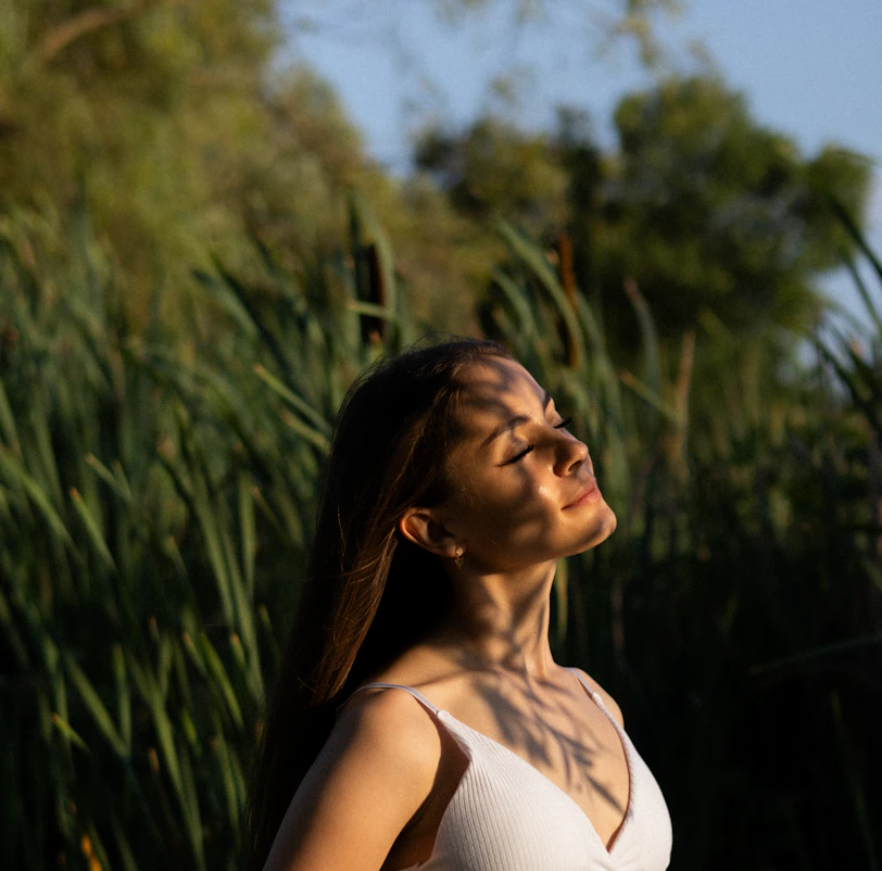 a woman standing in front of tall grass