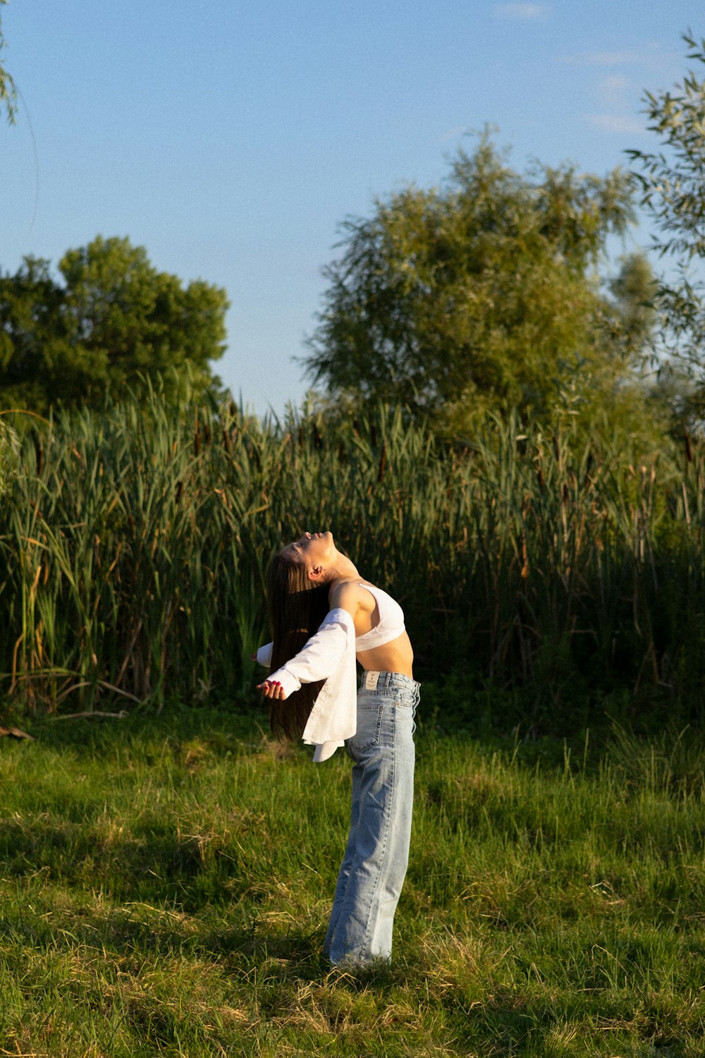 a woman standing in a field holding a frisbee