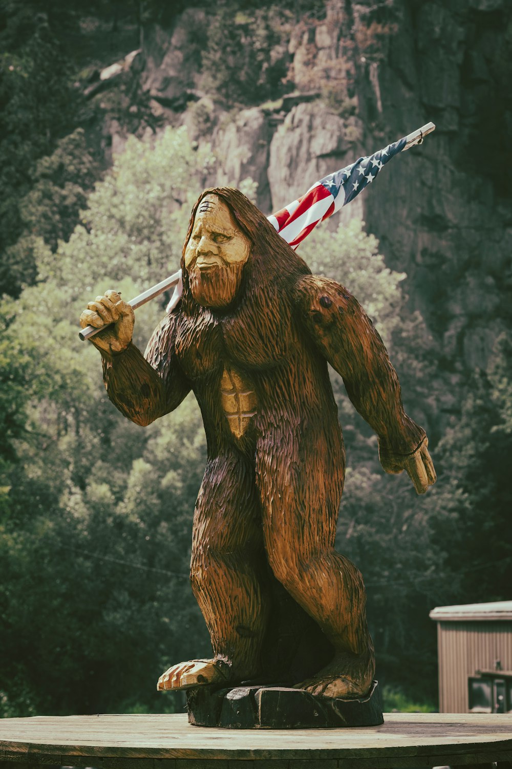 a statue of a bigfoot holding an american flag