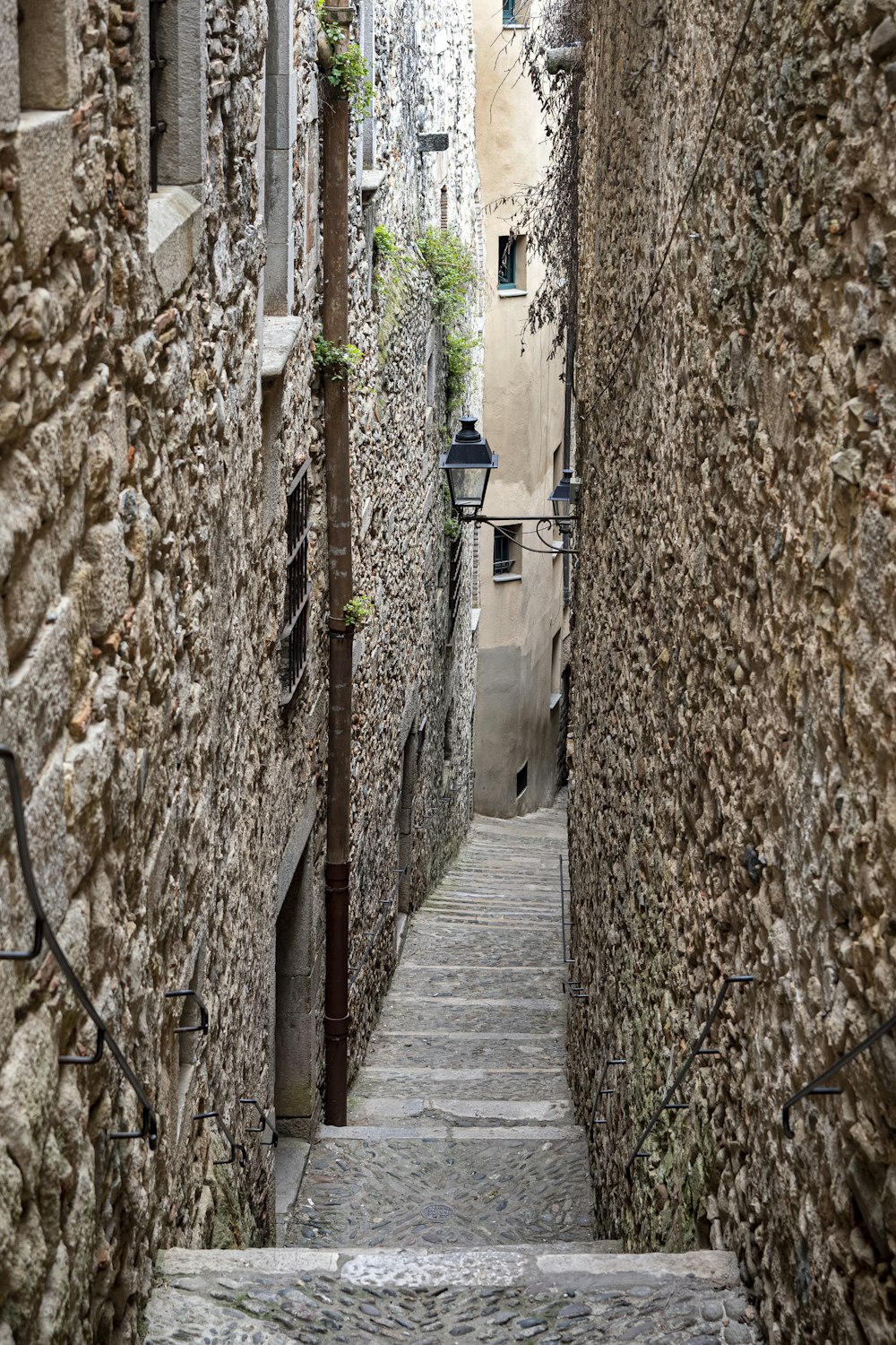 a narrow alleyway with stone walls and steps