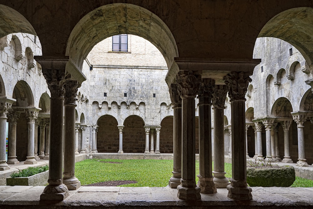 a courtyard with columns and grass in the middle