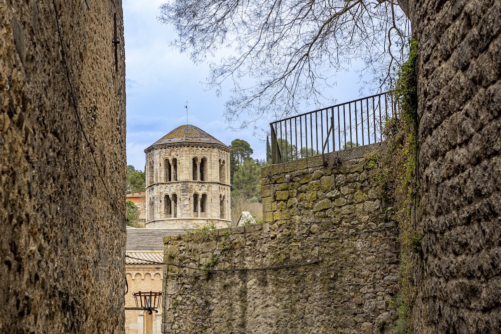 a stone wall with a building in the background