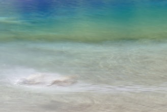 Abstract calming waves of blue and green blending softly into a peaceful horizon.