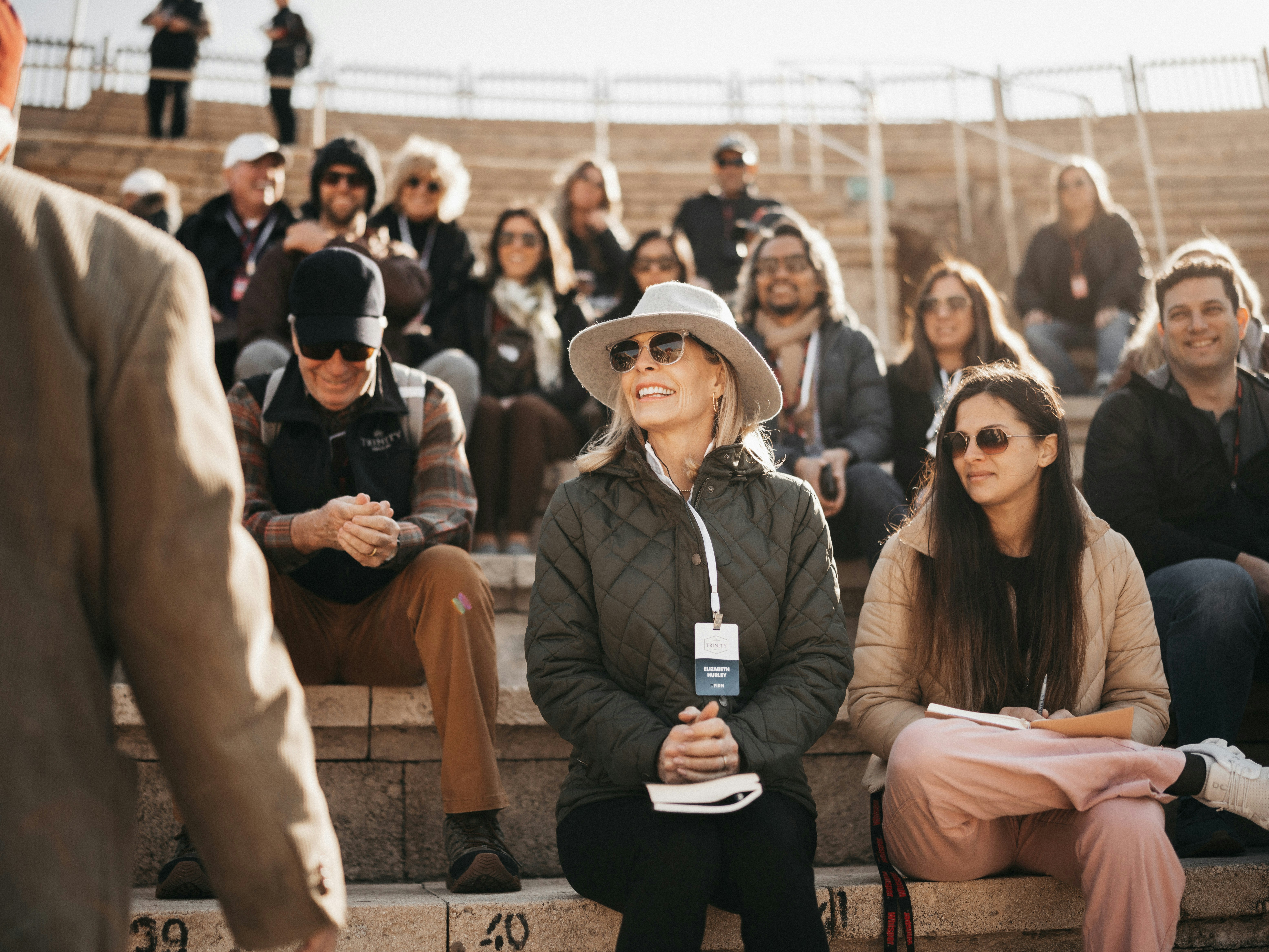 A group of people sitting on the bleachers