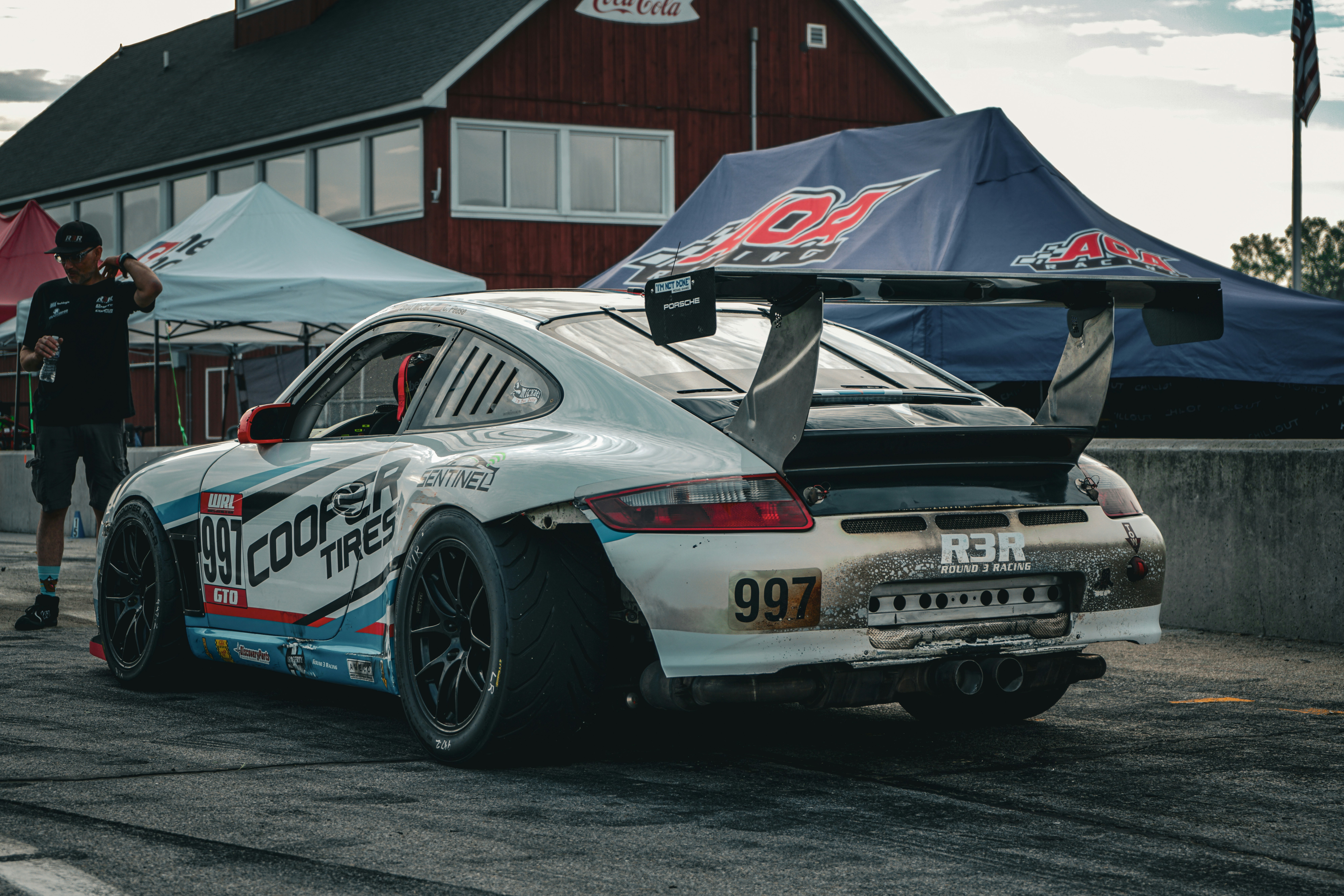 a man standing next to a race car on a race track