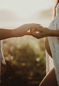 Close-up of intertwined hands bathed in soft golden light.