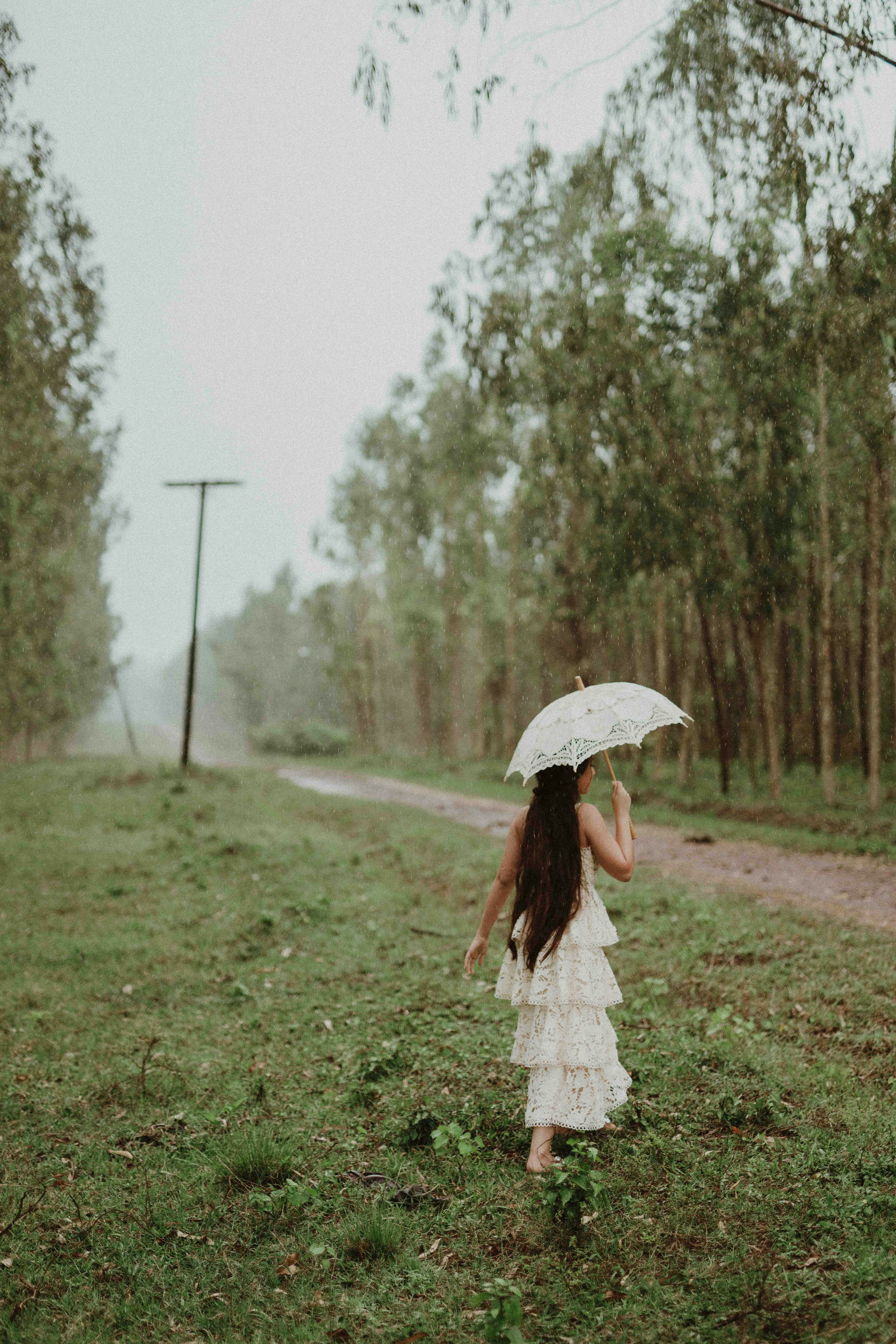 a girl in a white dress holding an umbrella