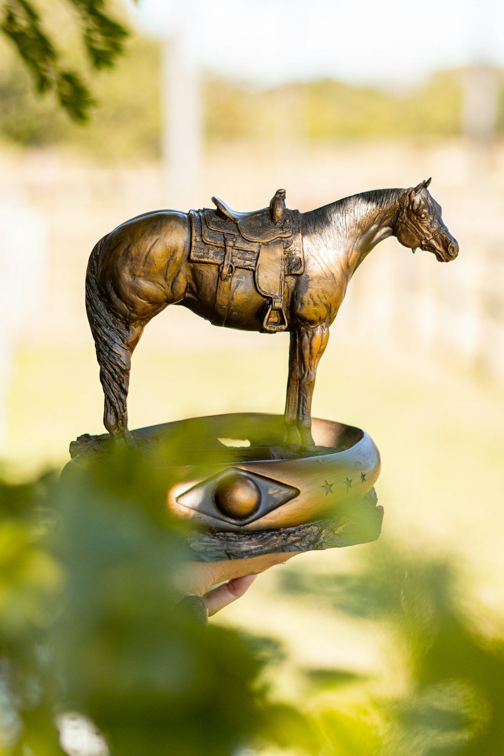 a bronze statue of a horse on top of a hand